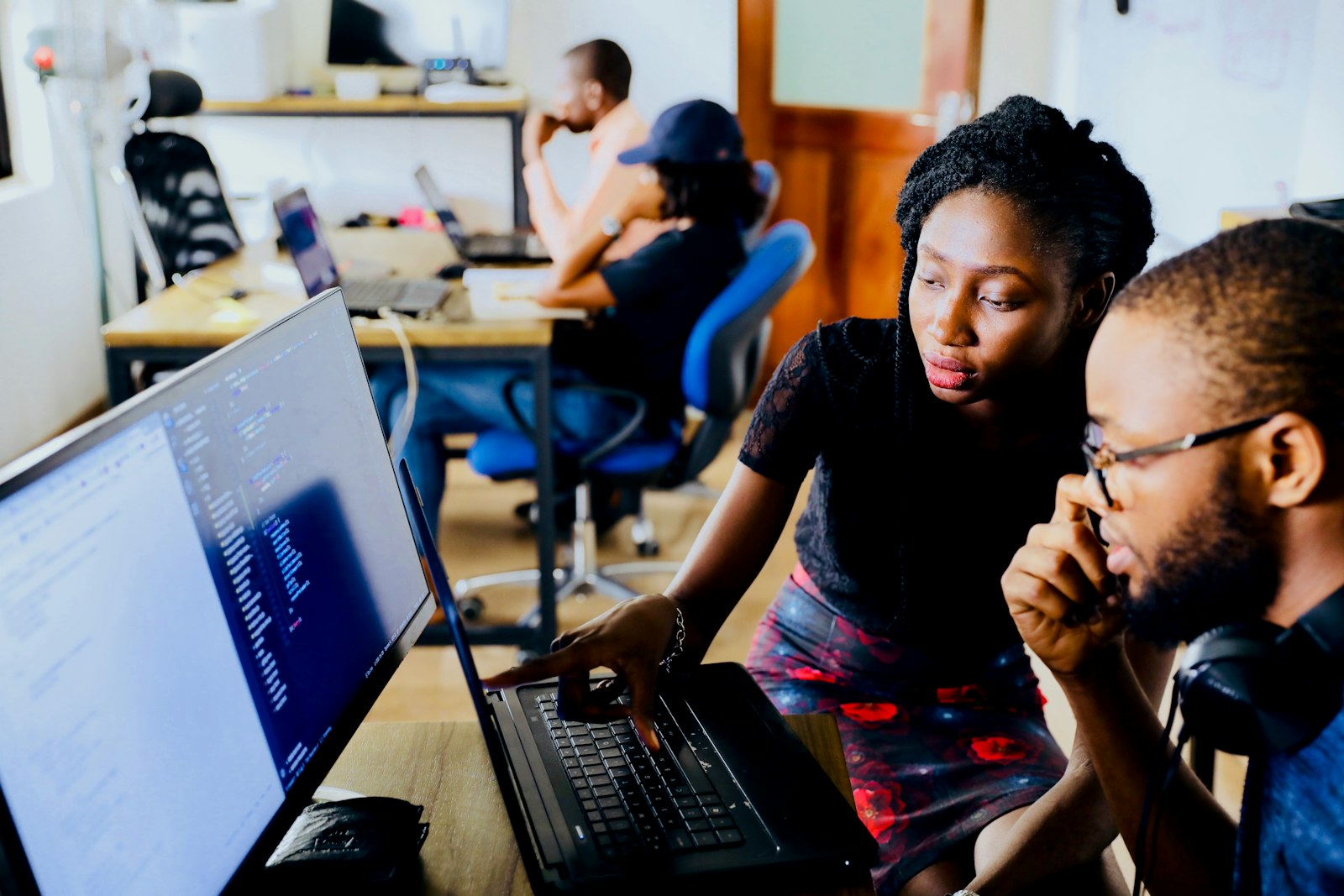 Two developers pair-programming with an AI assistant on screen